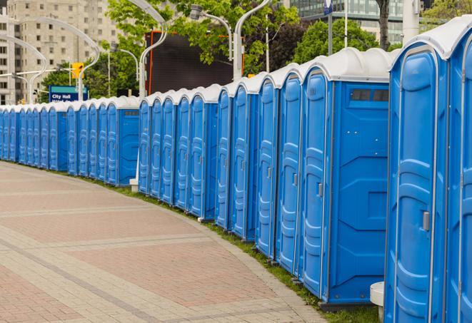 a fleet of portable restrooms ready for use at a large outdoor wedding or celebration in Alhambra